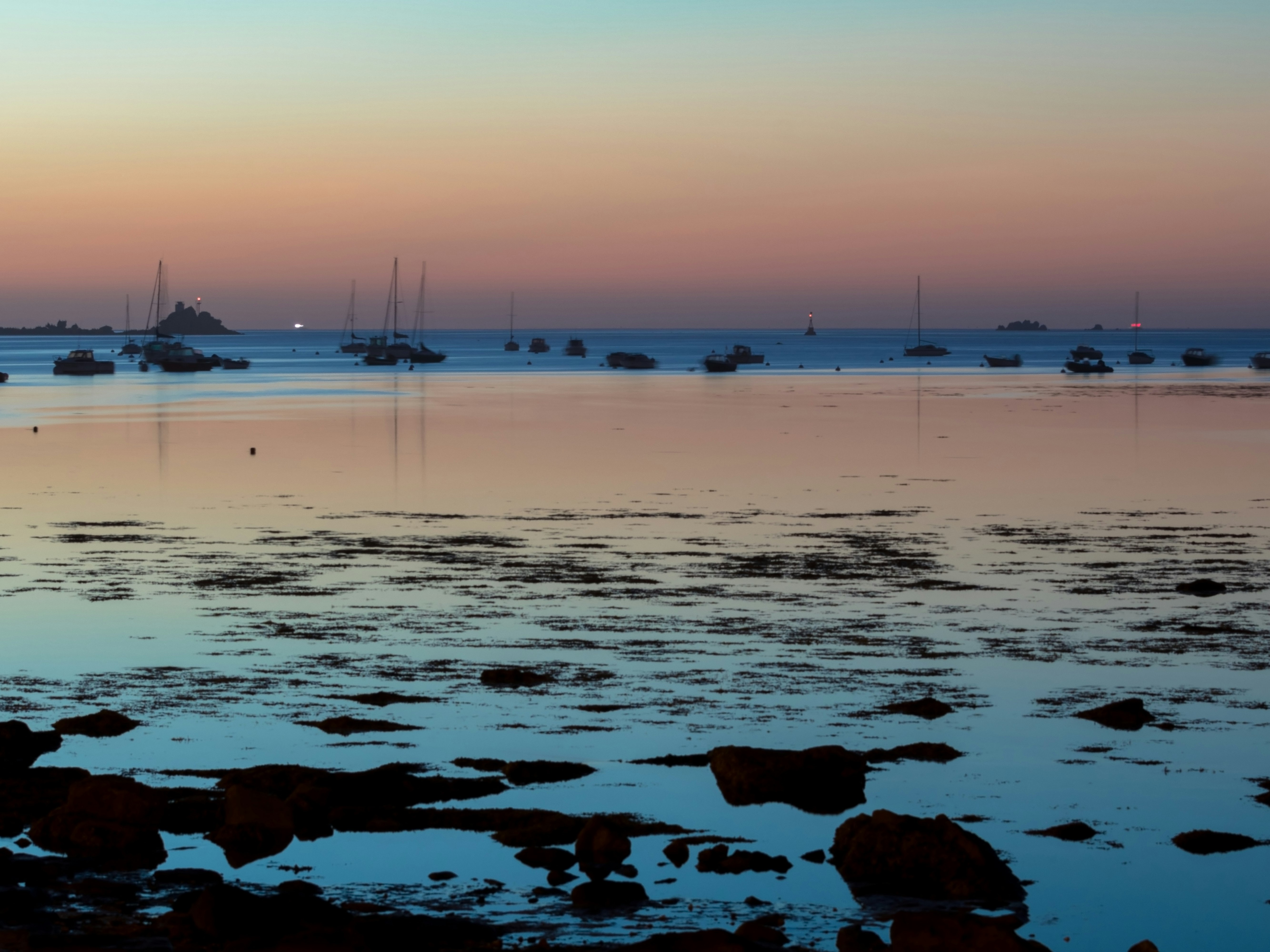 boats on seashore during golden hour